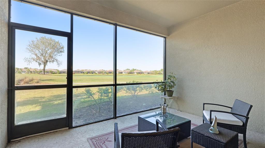 13719 Messina Loop, Unit 101 Lakewood Ranch, FL 34211 - Photo 19 of 77 a view of a room with workspace large windows and wooden floor