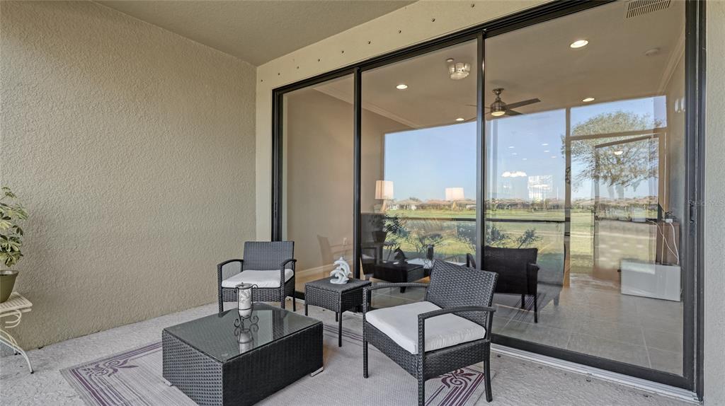 13719 Messina Loop, Unit 101 Lakewood Ranch, FL 34211 - Photo 21 of 77 a living room with furniture and a floor to ceiling window