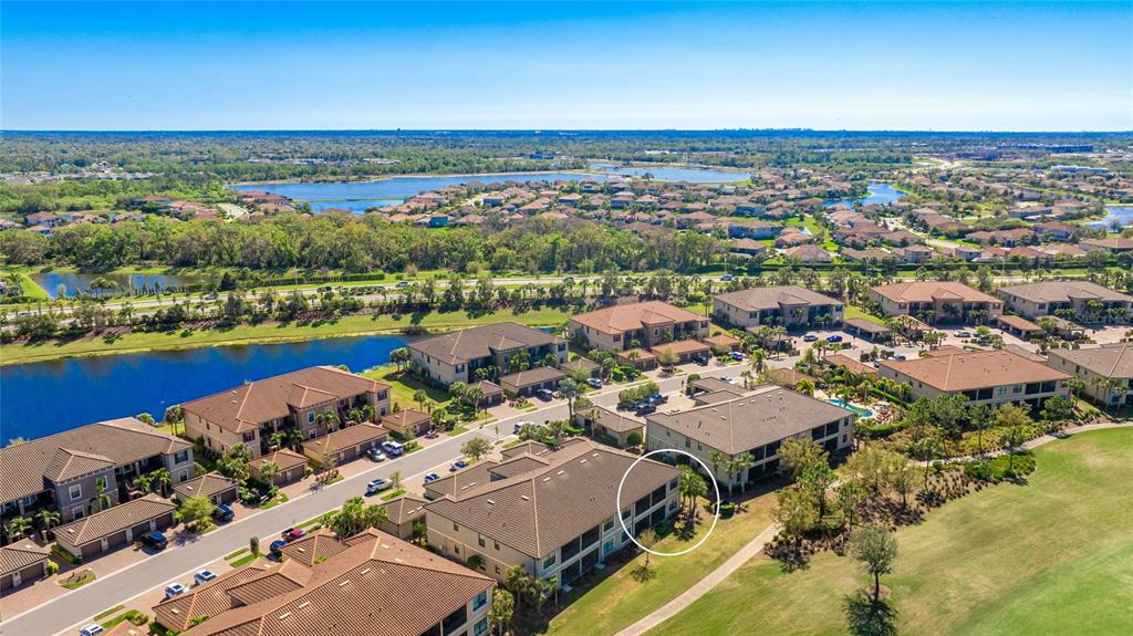 13719 Messina Loop, Unit 101 Lakewood Ranch, FL 34211 - Photo 32 of 77 an aerial view of a city with lots of residential buildings and ocean view in back
