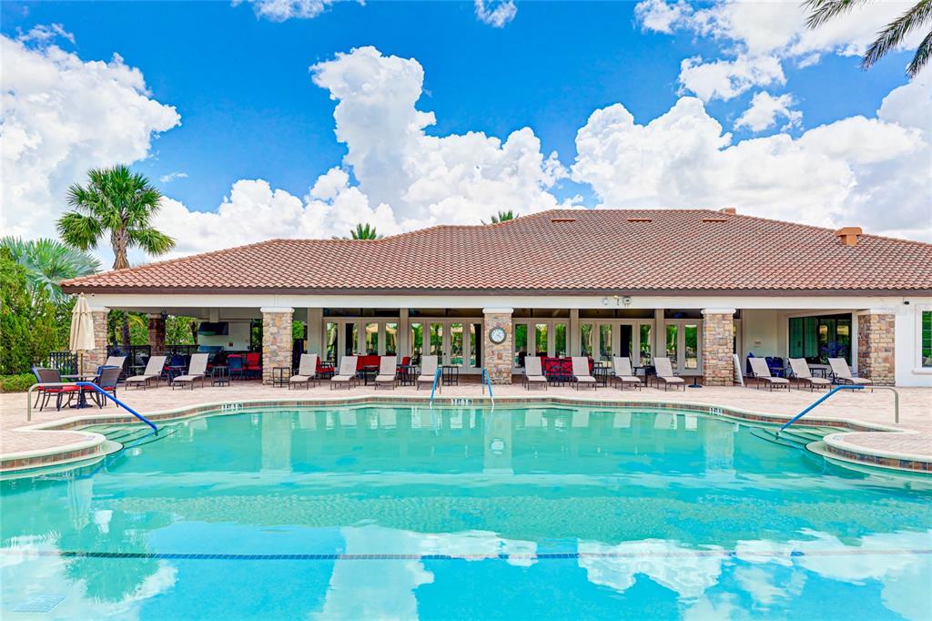 13719 Messina Loop, Unit 101 Lakewood Ranch, FL 34211 - Photo 74 of 77 a front view of a house with a yard table and chairs