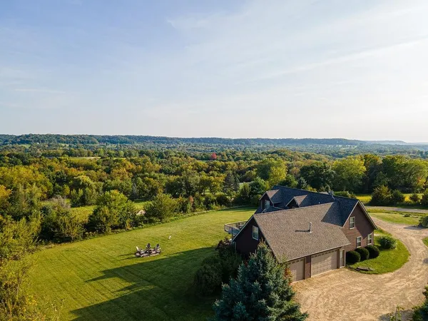 a view of a brick house next to a yard with big trees