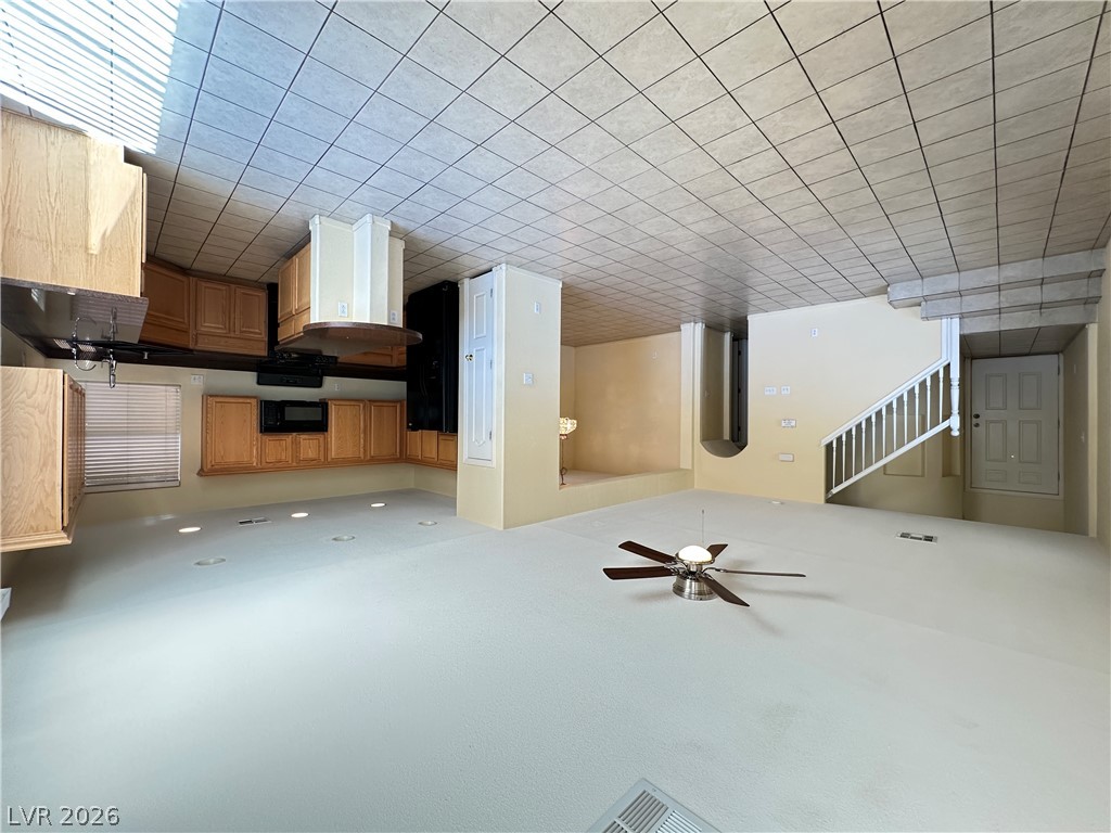 9032 Rutherford Grove Street Las Vegas, NV 89148 - Photo 3 of 24 An open-concept living space integrates a functional kitchen with seamless flow to the entrance and staircase.