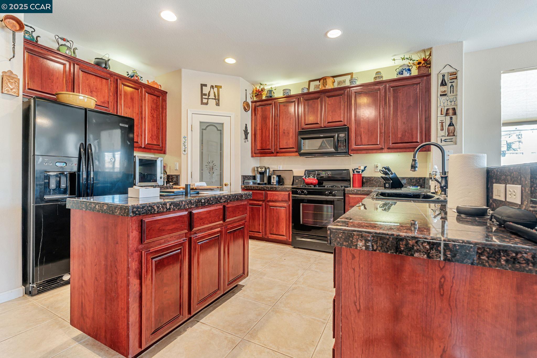 20640 Sarazen Place Patterson, CA 95363 - Photo 7 of 28 a kitchen with stainless steel appliances granite countertop a stove a sink dishwasher a refrigerator and a oven