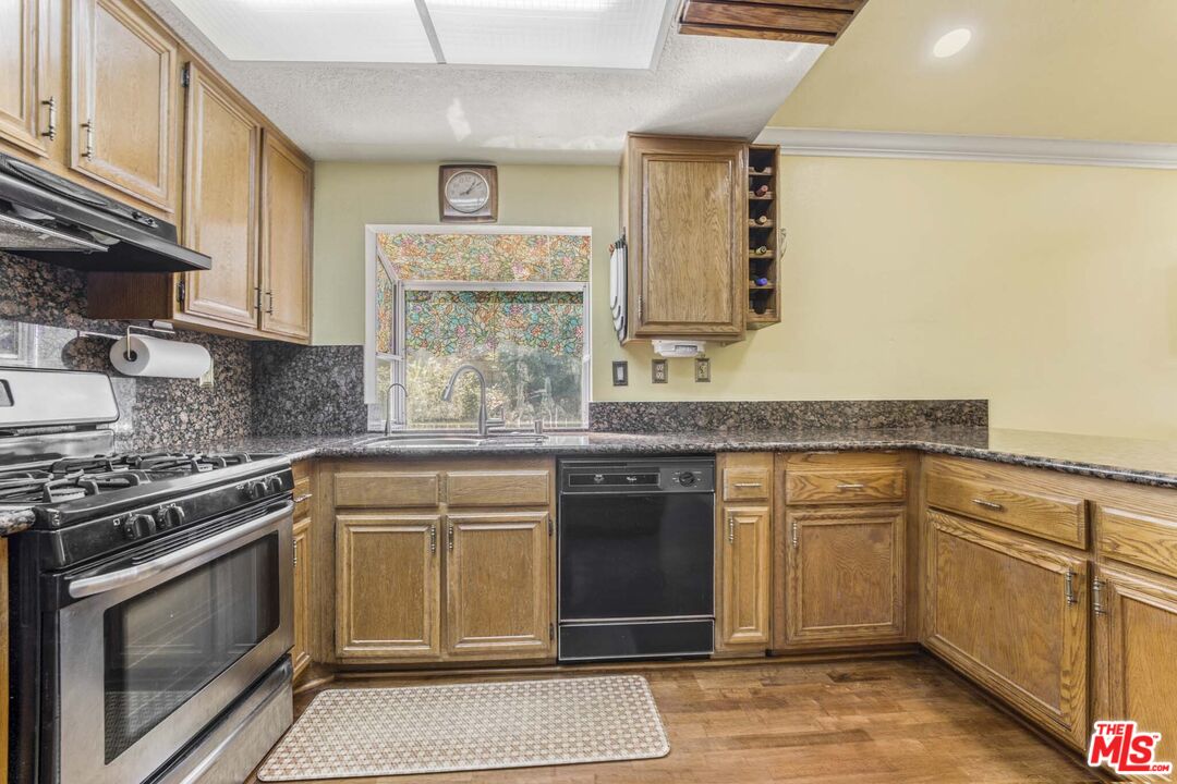 28135 Royal Road Castaic, CA 91384 - Photo 11 of 37 a kitchen with granite countertop cabinets stainless steel appliances and a counter space