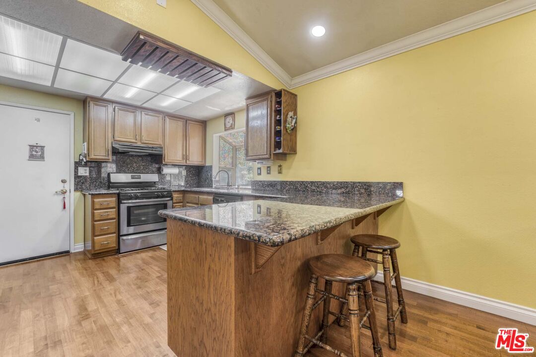 28135 Royal Road Castaic, CA 91384 - Photo 9 of 37 a kitchen with granite countertop a sink a counter top space and stainless steel appliances