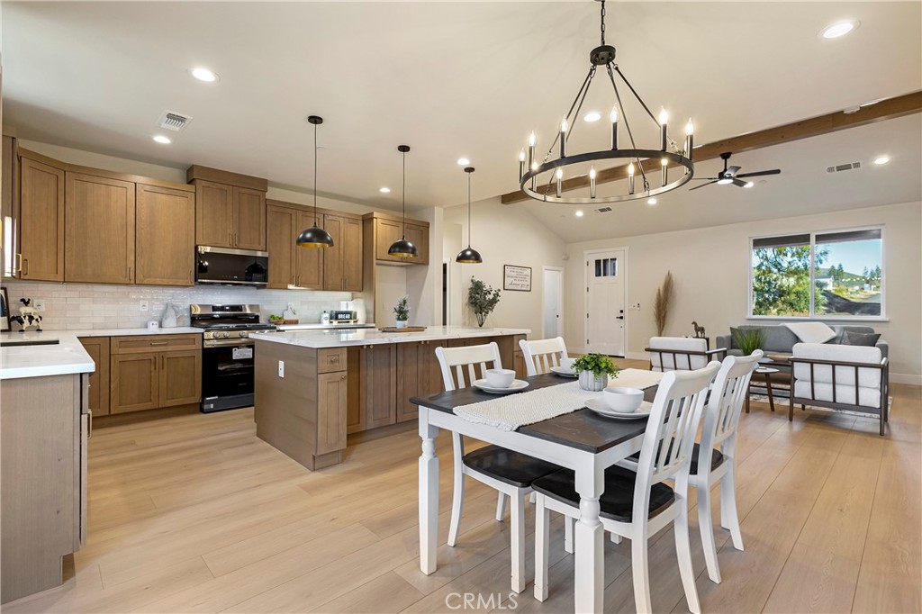 6185 Pentz Road Paradise, CA 95969 - Photo 16 of 53 a kitchen with stainless steel appliances kitchen island granite countertop a table chairs and a refrigerator