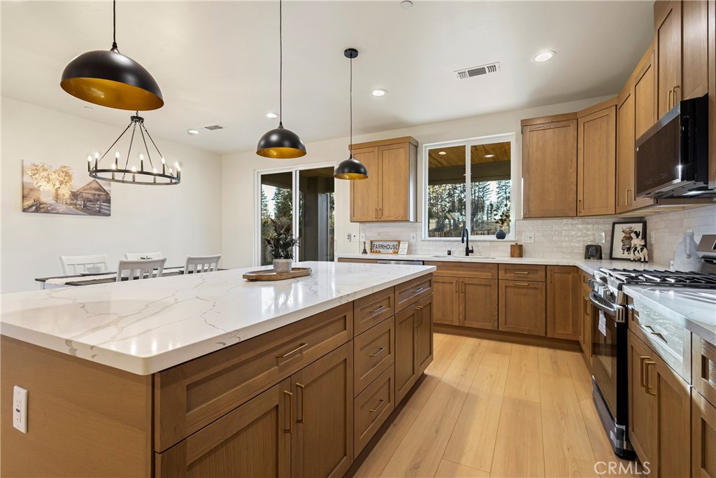 6185 Pentz Road Paradise, CA 95969 - Photo 18 of 53 a kitchen with stainless steel appliances granite countertop a sink a stove and a wooden floors