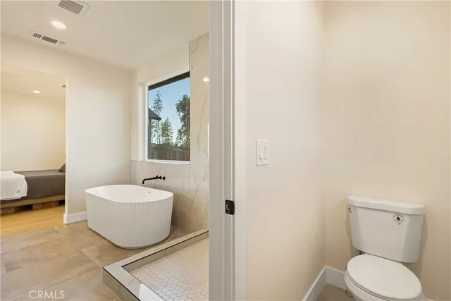 a spacious bathroom with a double vanity sink mirror and bathtub