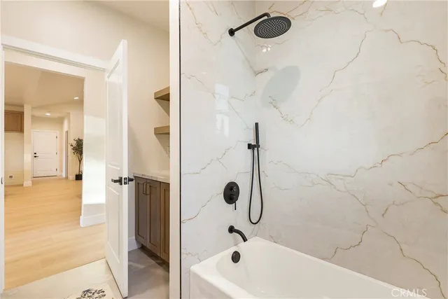 a living room with a bed and a wooden floor