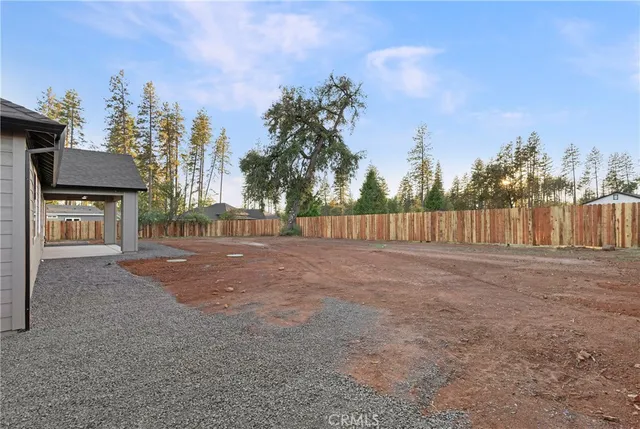 a view of a house with backyard and trees