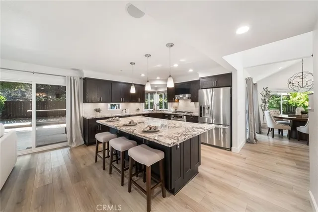 a kitchen with granite countertop a sink and chairs