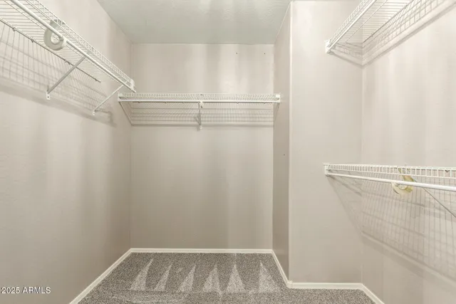 a view of walk in closet with clothes