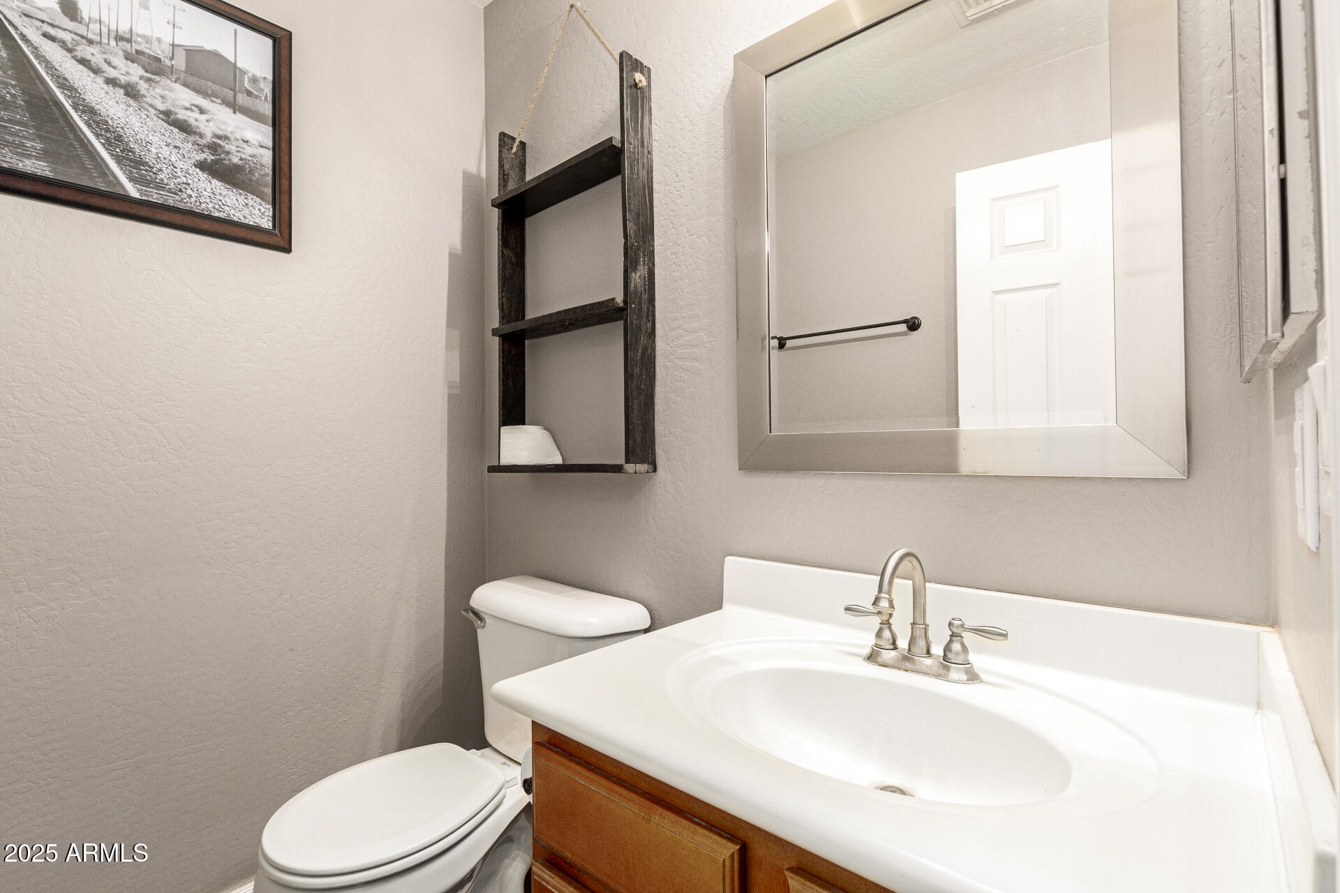 161 South 21st Street Coolidge, AZ 85128 - Photo 25 of 32 a bathroom with a toilet a sink and mirror