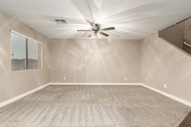 an empty room with windows and fan