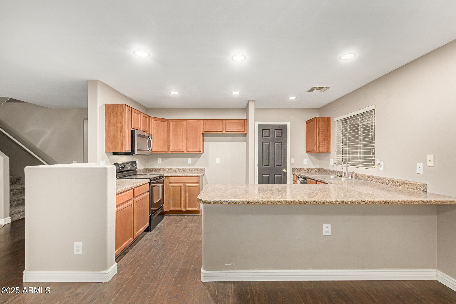 161 South 21st Street Coolidge, AZ 85128 - Photo 8 of 32 a large kitchen with kitchen island a stove a sink a refrigerator wooden floor and cabinets