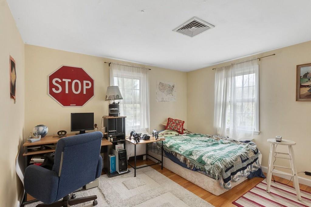 204 Sterling Road Lancaster, MA 01523 - Photo 40 of 41 a bedroom with a bed and wooden floor