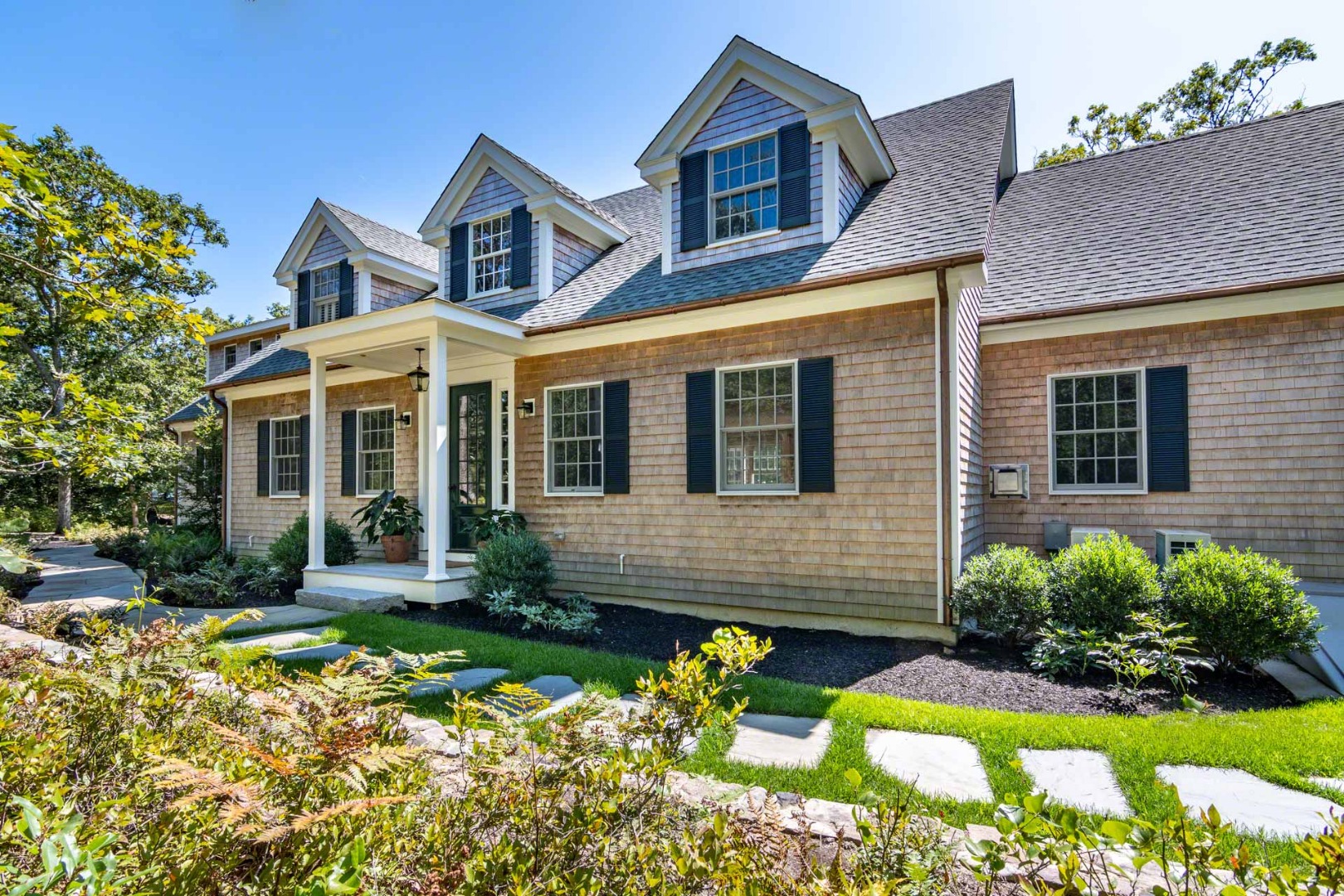 a front view of a house with a yard and outdoor seating