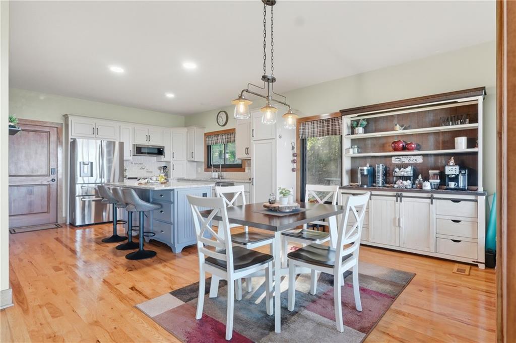 49 Rimrock Road Jasper, GA 30143 - Photo 17 of 61 a kitchen with stainless steel appliances kitchen island granite countertop a refrigerator a stove a dining table and chairs with wooden floor