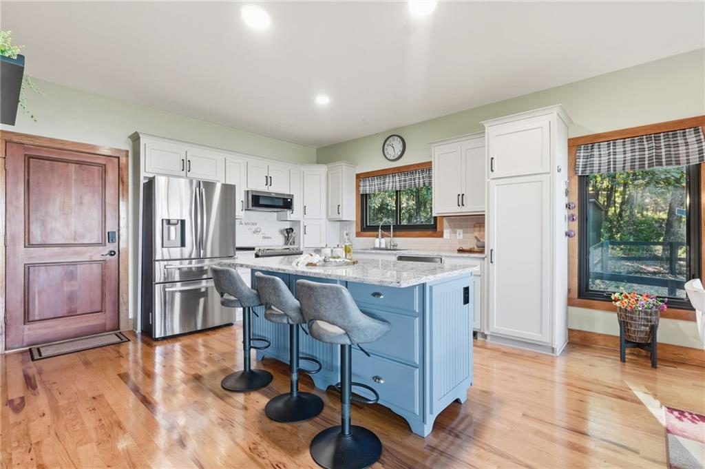 49 Rimrock Road Jasper, GA 30143 - Photo 19 of 61 a kitchen with a refrigerator a stove top oven and a dining table with wooden floor