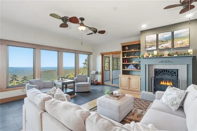 a living room with furniture large window and flat screen tv