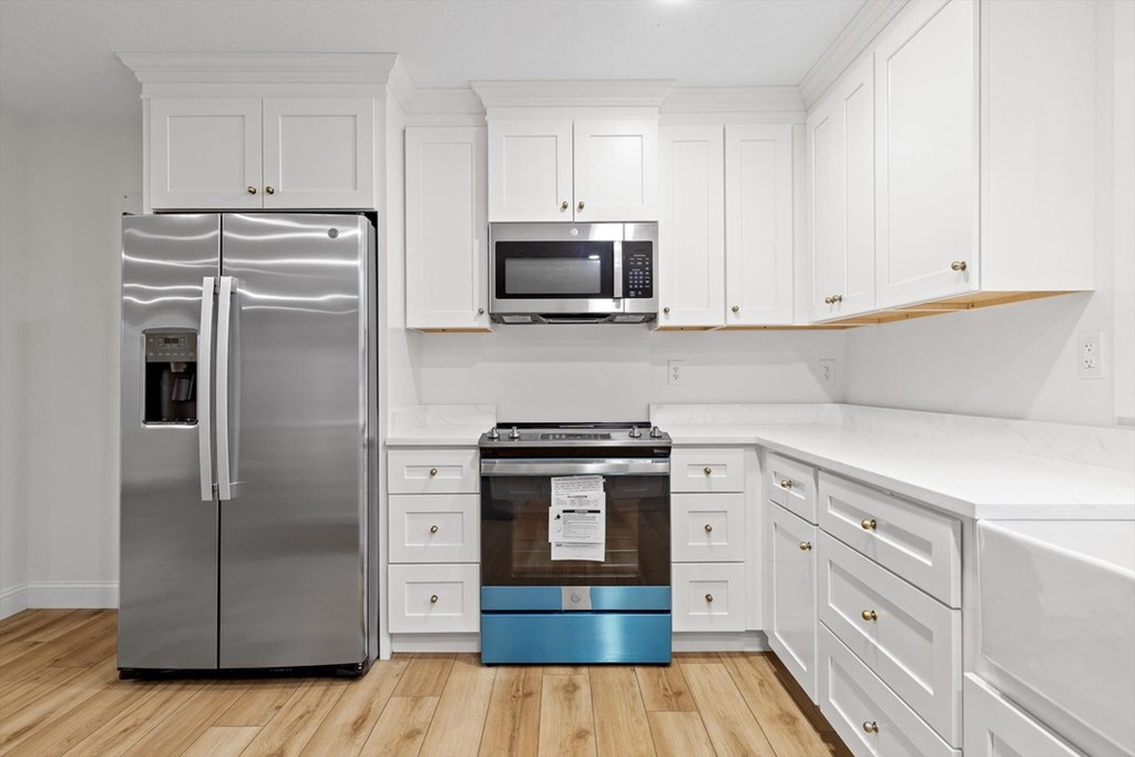 446 Brown Bridge Road Chatsworth, GA 30705 - Photo 52 of 77 a kitchen with cabinets stainless steel appliances and wooden floor