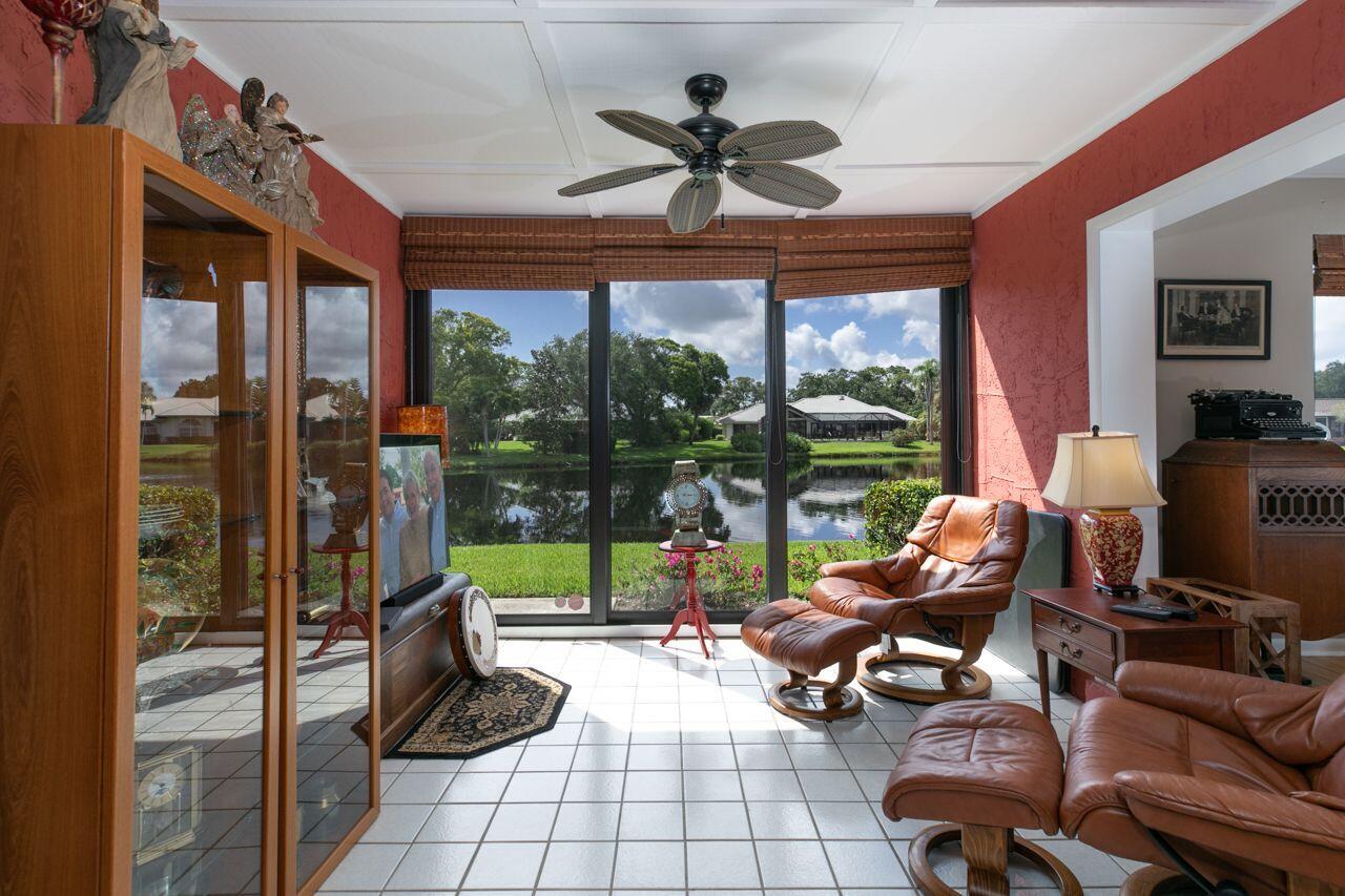 5606 Southeast Foxcross Place Stuart, FL 34997 - Photo 15 of 65 a living room filled with furniture and a floor to ceiling window