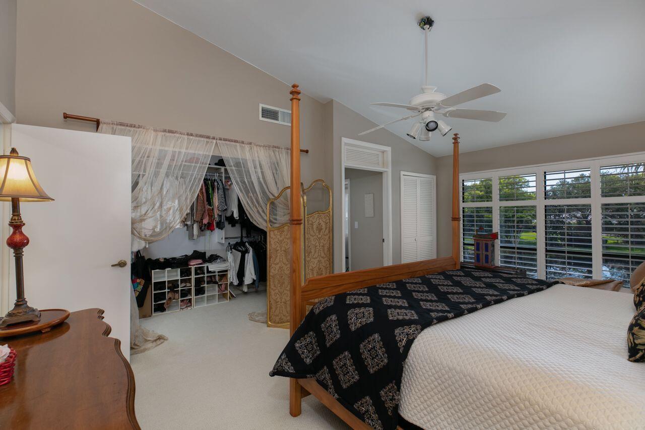 5606 Southeast Foxcross Place Stuart, FL 34997 - Photo 20 of 65 a bedroom with a bed and a chandelier