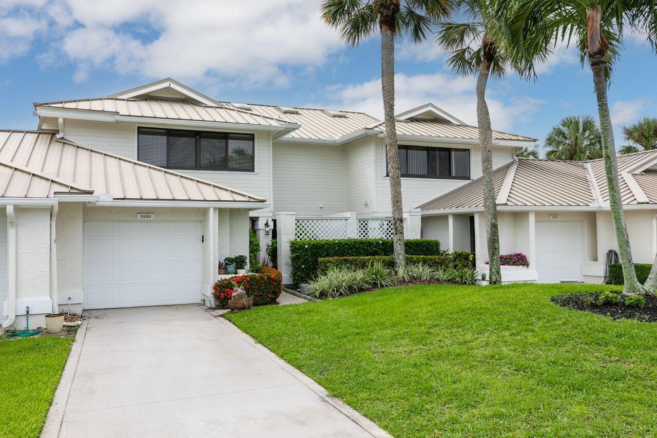 5606 Southeast Foxcross Place Stuart, FL 34997 - Photo 2 of 65 a front view of a house with a garden and palm trees