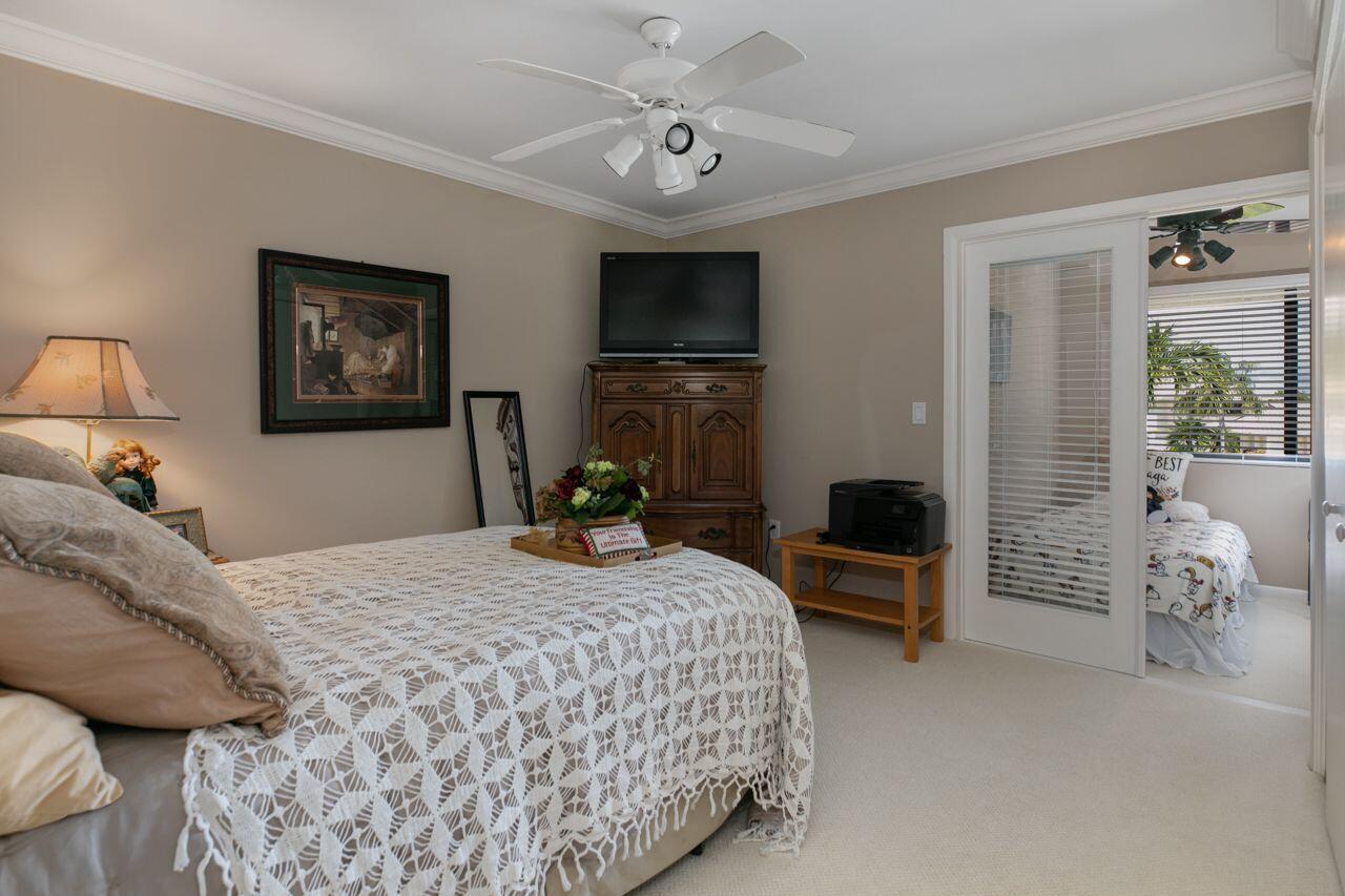 5606 Southeast Foxcross Place Stuart, FL 34997 - Photo 24 of 65 a bedroom with a bed and a chandelier