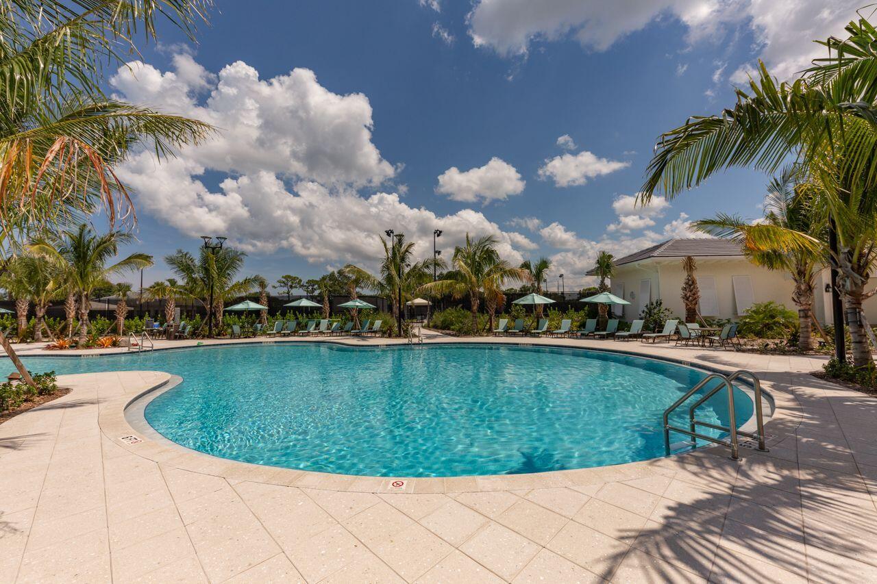 5606 Southeast Foxcross Place Stuart, FL 34997 - Photo 46 of 65 a view of a swimming pool with a table and chairs under an umbrella