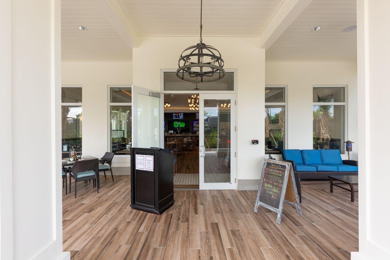 5606 Southeast Foxcross Place Stuart, FL 34997 - Photo 53 of 65 a dining room with wooden floor a chandelier a wooden table and chairs