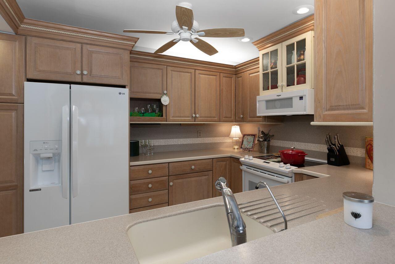 5606 Southeast Foxcross Place Stuart, FL 34997 - Photo 10 of 65 a kitchen with stainless steel appliances granite countertop a refrigerator and a stove top oven