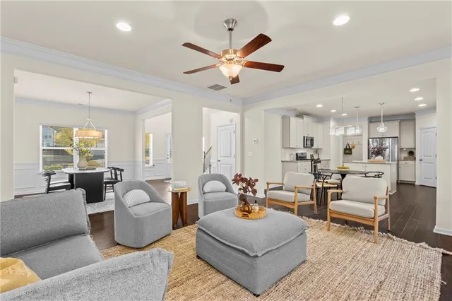 a living room with furniture kitchen view and a chandelier