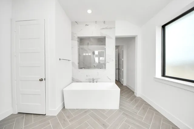 a bathroom with a bathtub sink and mirror