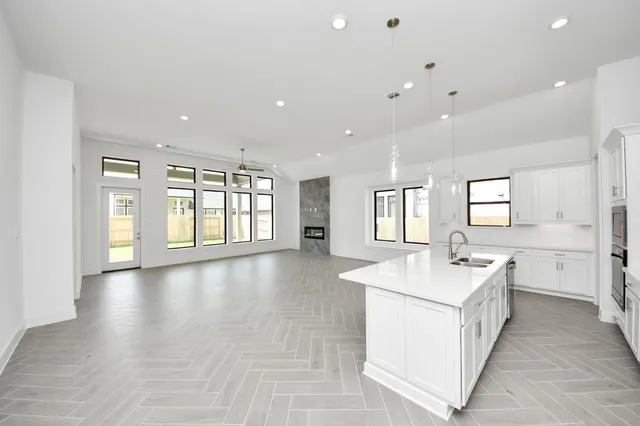 a large white kitchen with a large window and stainless steel appliances