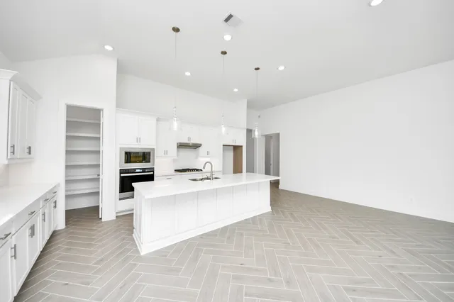 a kitchen with stainless steel appliances granite countertop a sink stove and refrigerator