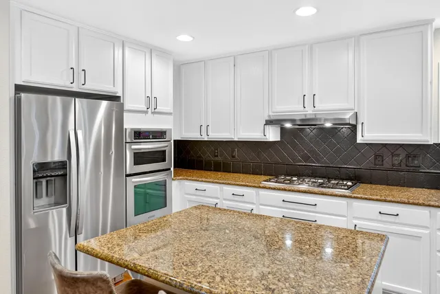 a bathroom with a granite countertop sink a toilet and shower