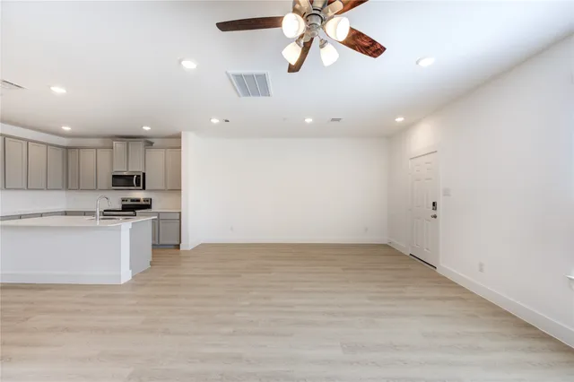 a view of kitchen with refrigerator and white cabinets