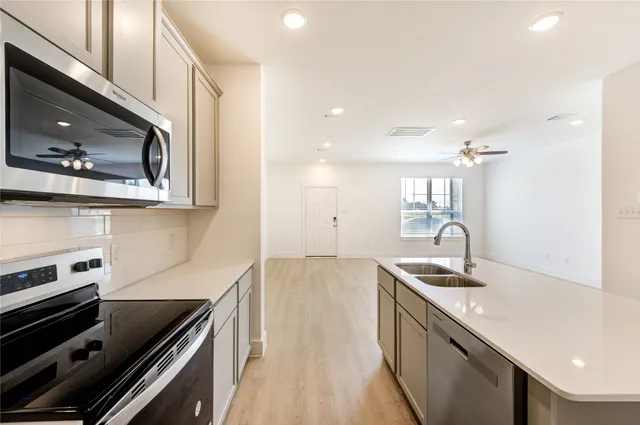 a kitchen with a sink stove and microwave