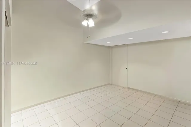 an empty room with a chandelier fan