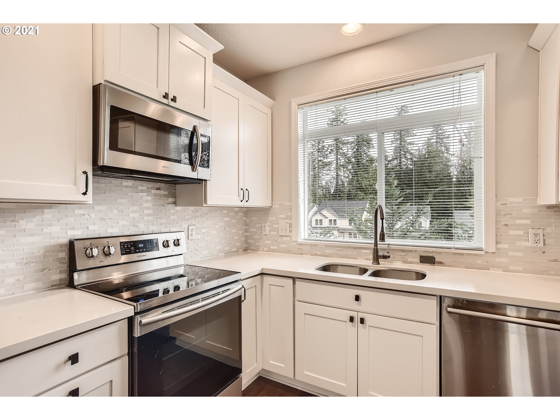 14540 Southeast Marci Way Clackamas, OR 97015 - Photo 10 of 32 a kitchen with stainless steel appliances granite countertop white cabinets a microwave oven and a sink