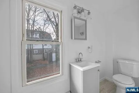 a bathroom with a toilet sink vanity and mirror