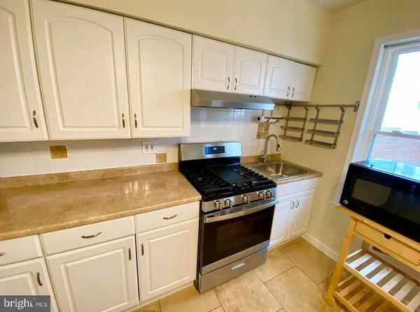 a kitchen with granite countertop white cabinets and appliances