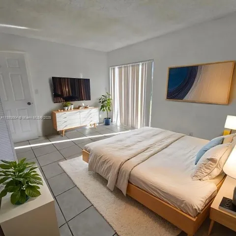 a bedroom with a bed a television and a couch