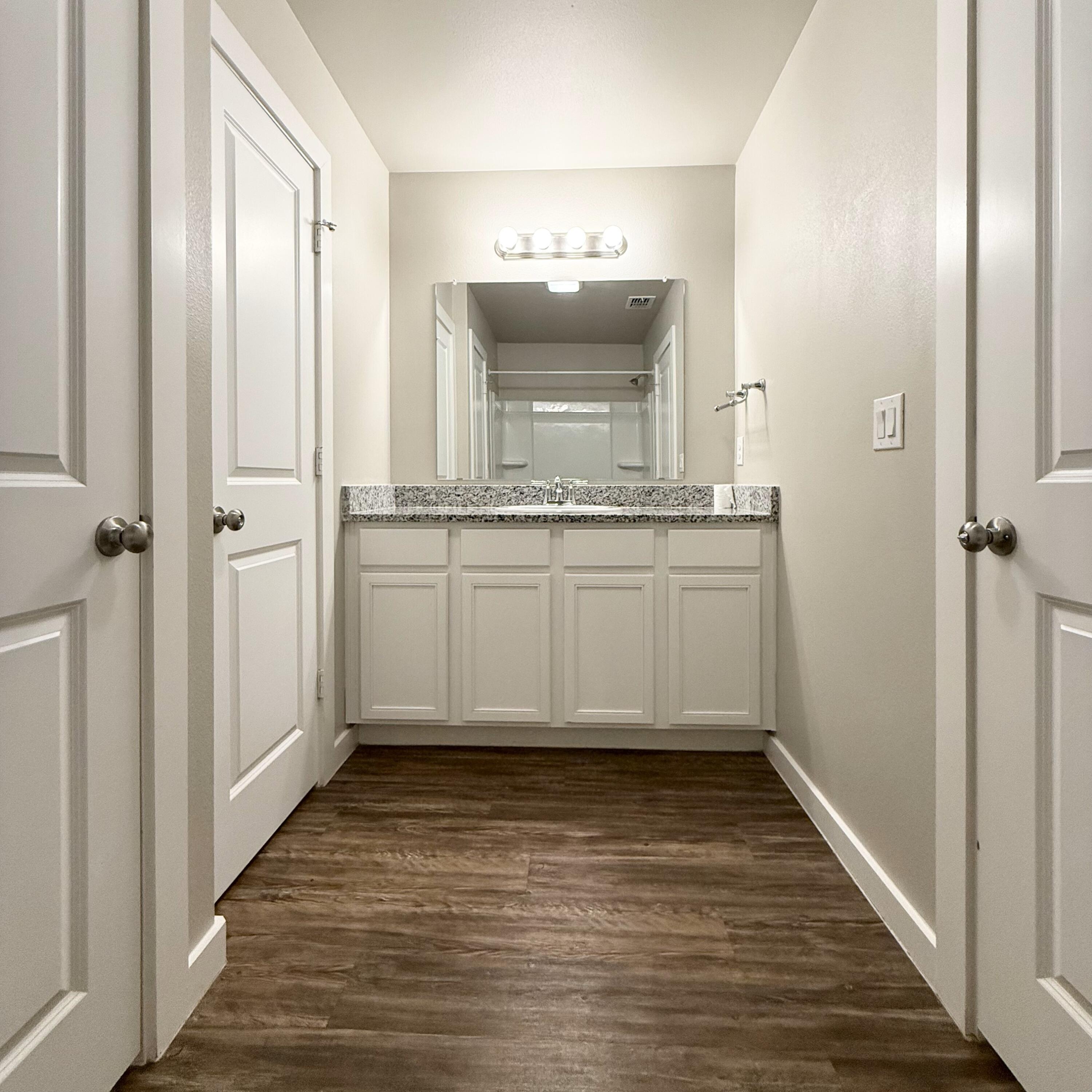 2108 North Jayton Avenue, Unit A Lubbock, TX 79403 - Photo 11 of 17 a bathroom with a sink a mirror and a shower