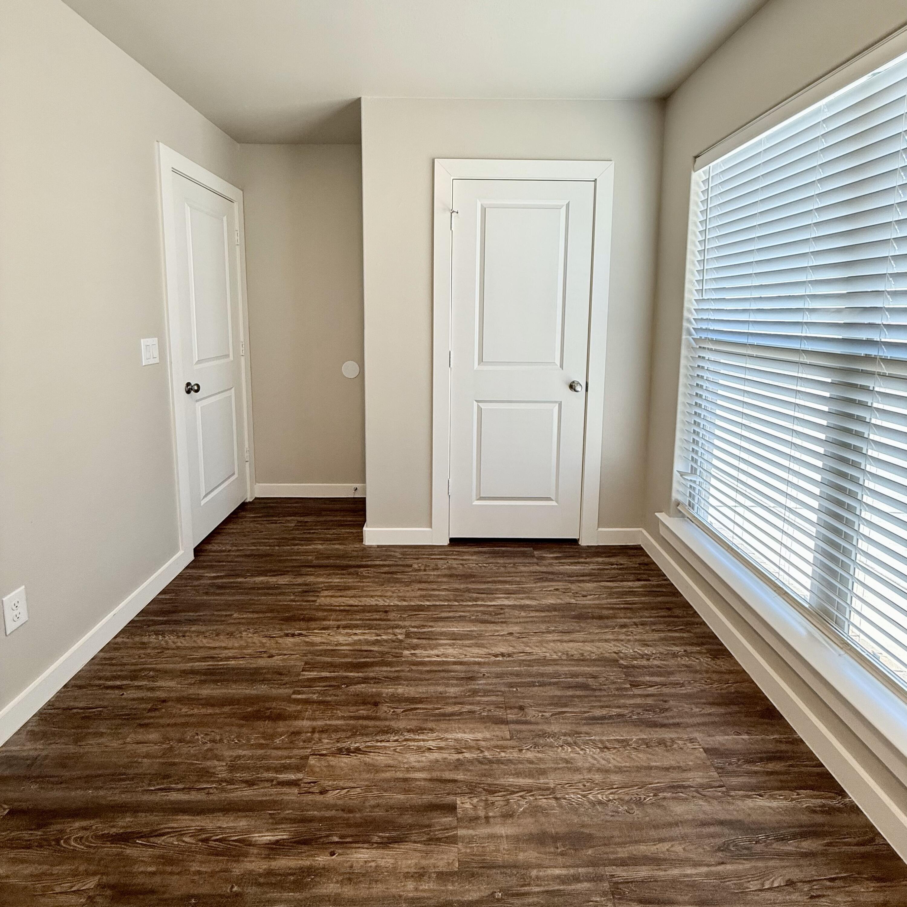 2108 North Jayton Avenue, Unit A Lubbock, TX 79403 - Photo 17 of 17 a view of an empty room with wooden floor and a window