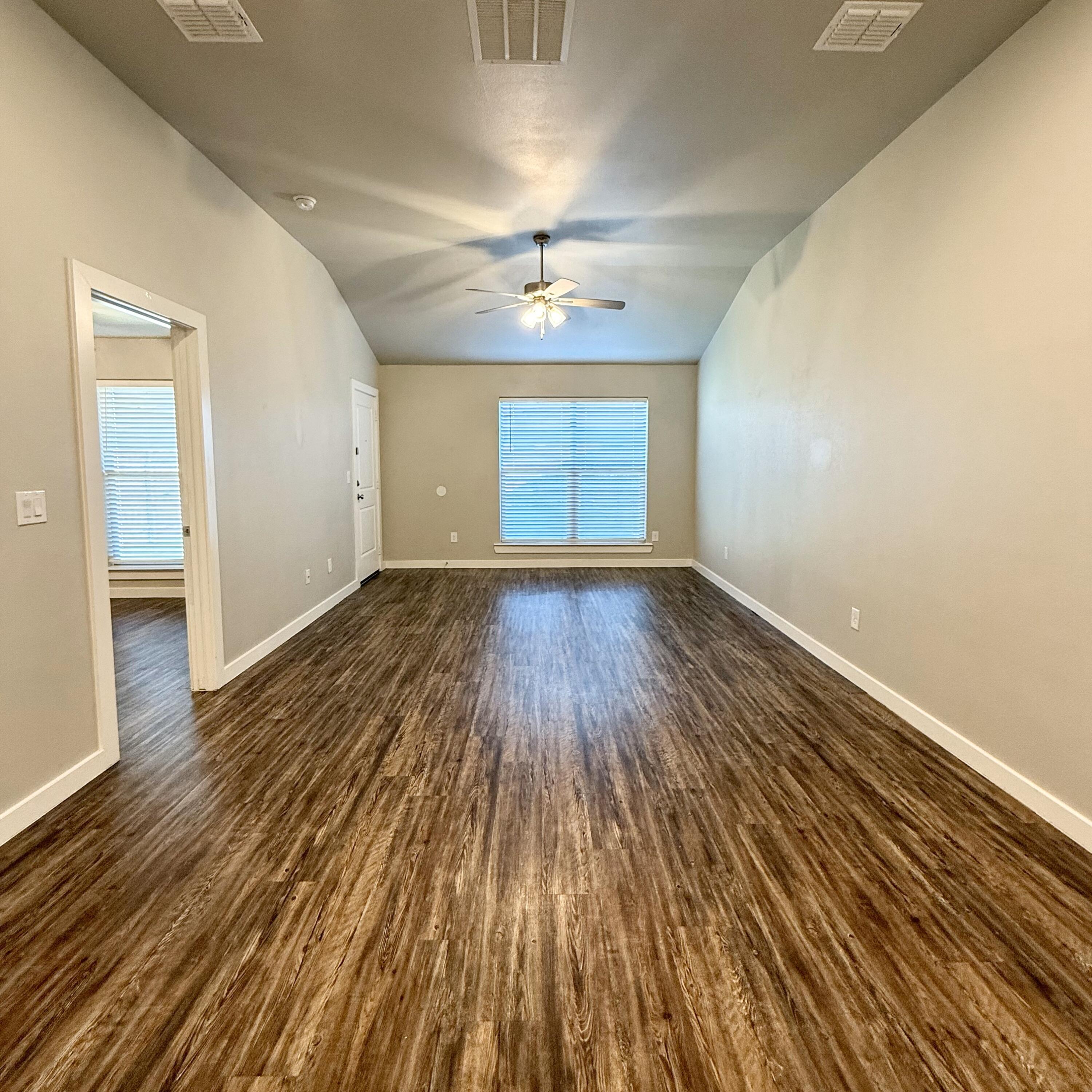 2108 North Jayton Avenue, Unit A Lubbock, TX 79403 - Photo 5 of 17 wooden floor in an empty room with a window