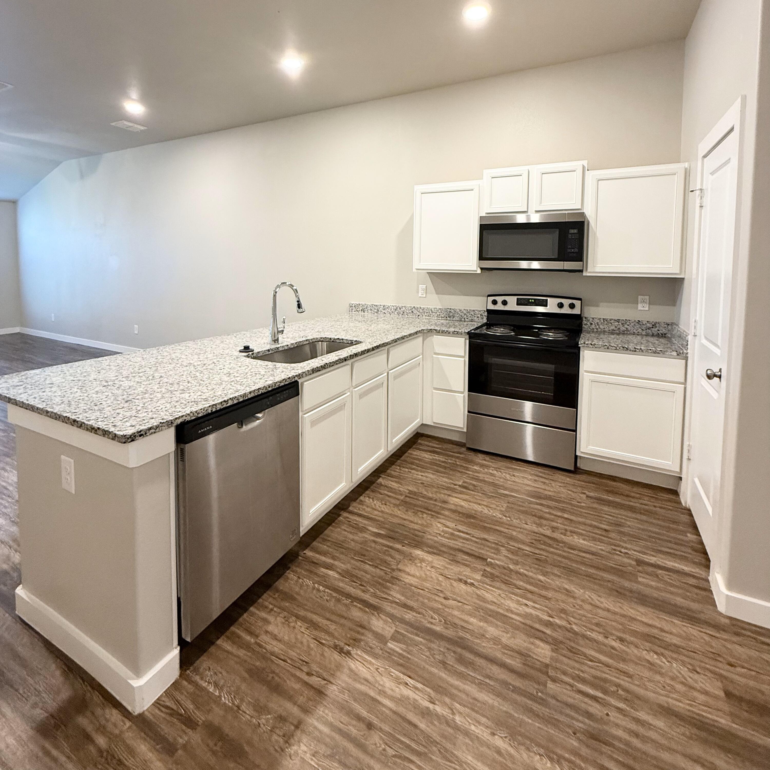 2108 North Jayton Avenue, Unit A Lubbock, TX 79403 - Photo 7 of 17 a kitchen with sink a microwave and cabinets