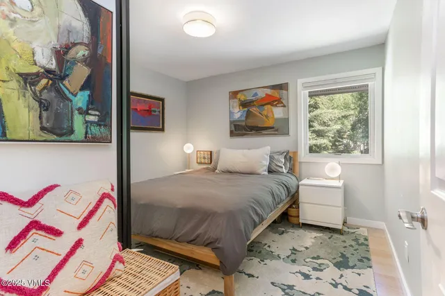 a bedroom with a bed and a painting on the wall