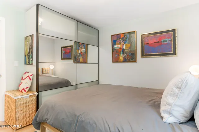 a bedroom with a bed and a painting on the wall